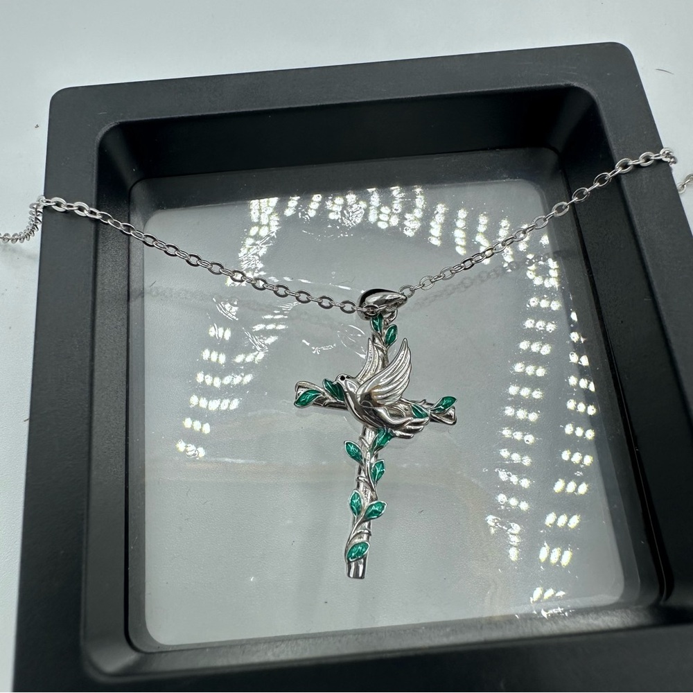 Silver Metal Cross on a Silver Chain With Green Leaves and a Dove of Peace